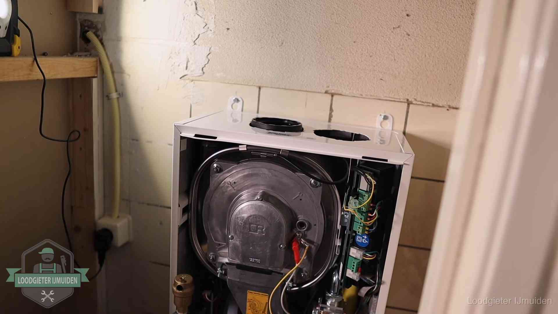 Onderhoudsbeurt cv-ketel in IJmuiden Geopende cv-ketel tijdens een onderhoudsbeurt in IJmuiden, met brander en warmtewisselaar zichtbaar