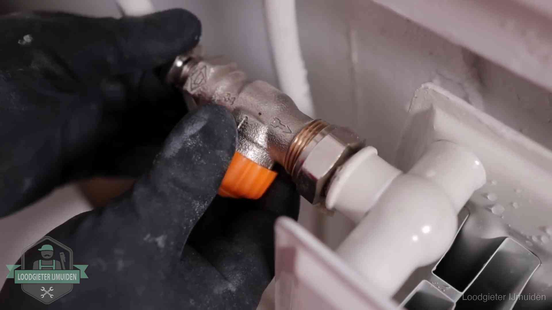 Je cv winterklaar maken in IJmuiden Thermostaatkraan wordt gemonteerd op een radiator in IJmuiden voor het stookseizoen