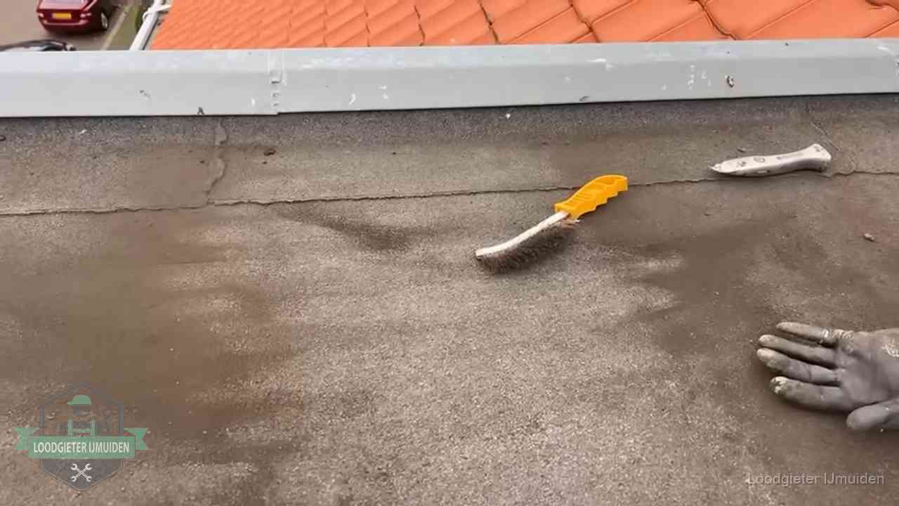 Dakdekker bereidt een bitumen plat dak voor op reparatie bij de daktrim in IJmuiden
