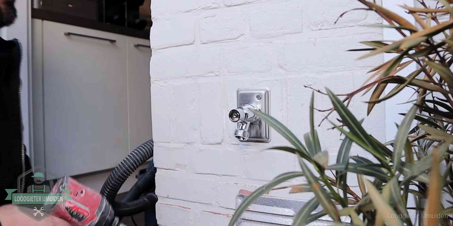 Chromen kraan op een muurplaat bij een woning in IJmuiden, dichtdraaien is stap een van de lektest