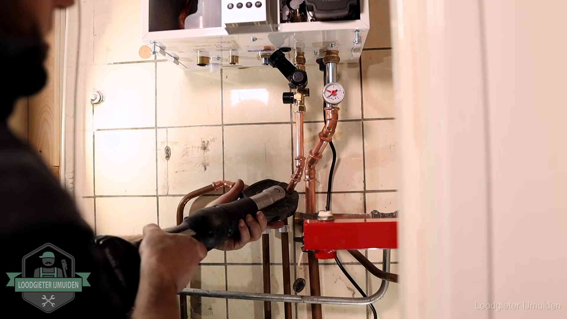 Cv-ketel onderhoud in IJmuiden Monteur werkt aan de leidingen onder een cv-ketel in IJmuiden