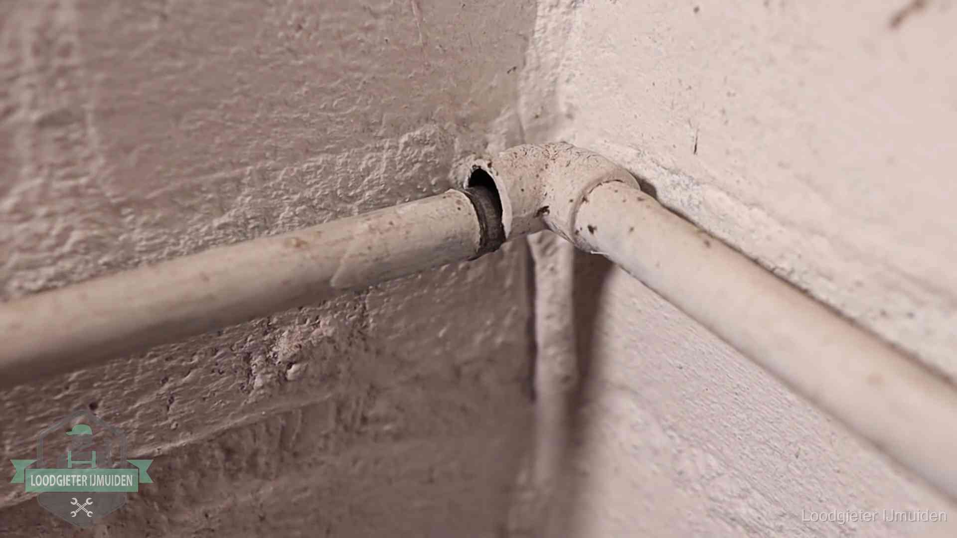 Oude waterleidingen en verborgen lekkage in IJmuiden Oude geverfde waterleiding met een losliggende fitting in een woning in IJmuiden