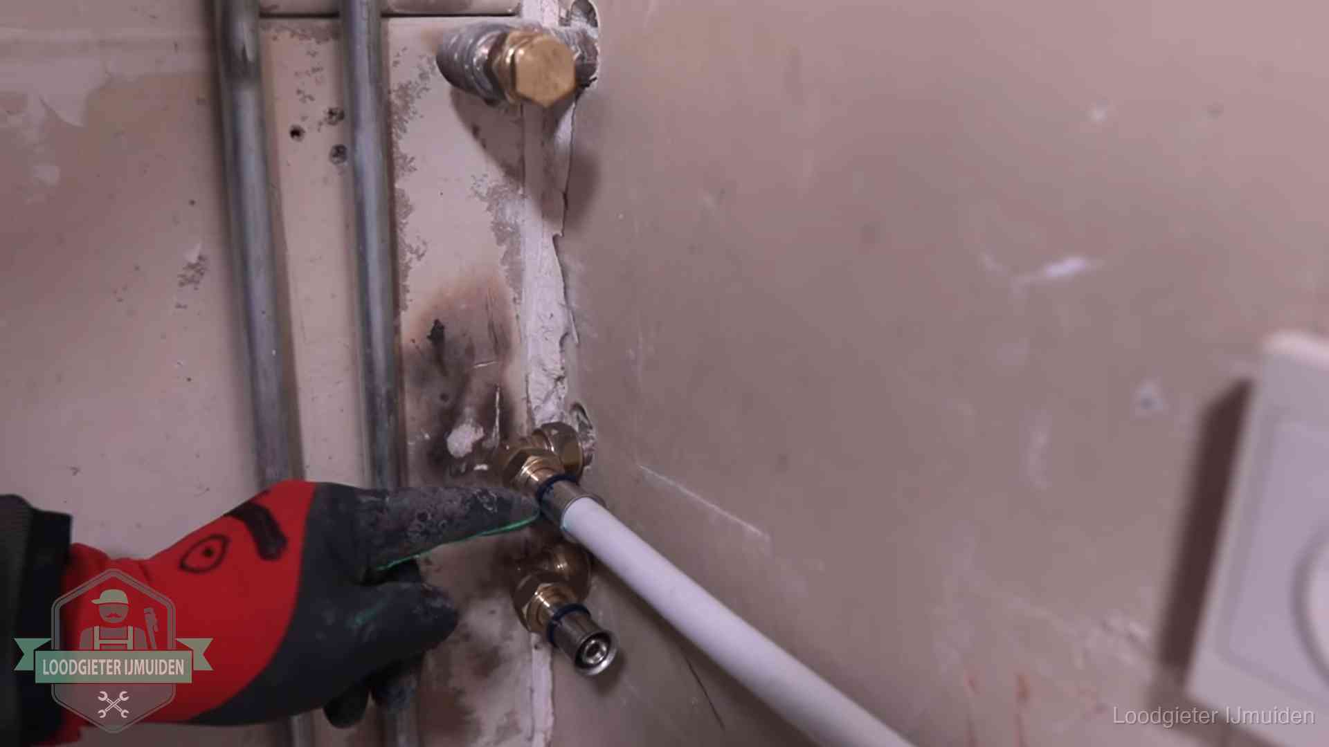 Garantie op loodgieterswerk in IJmuiden Loodgieter wijst de persfitting op nieuwe muuraansluitingen aan in een woning in IJmuiden