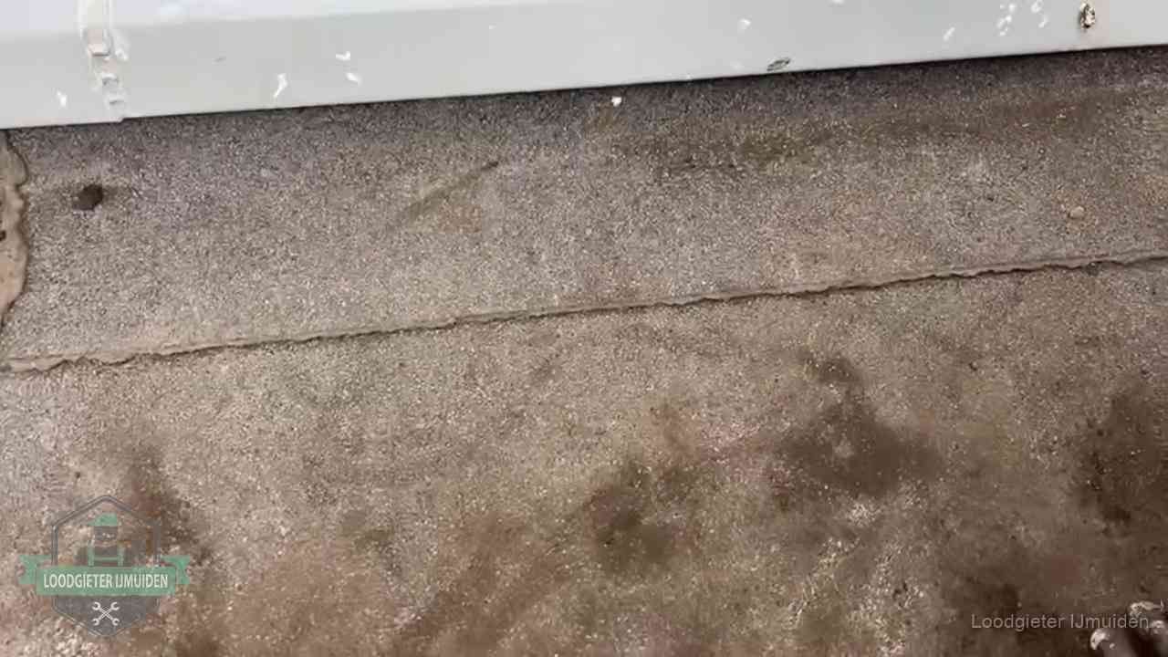 Vochtplekken bij de naad van een plat dak na aanhoudende regen in IJmuiden