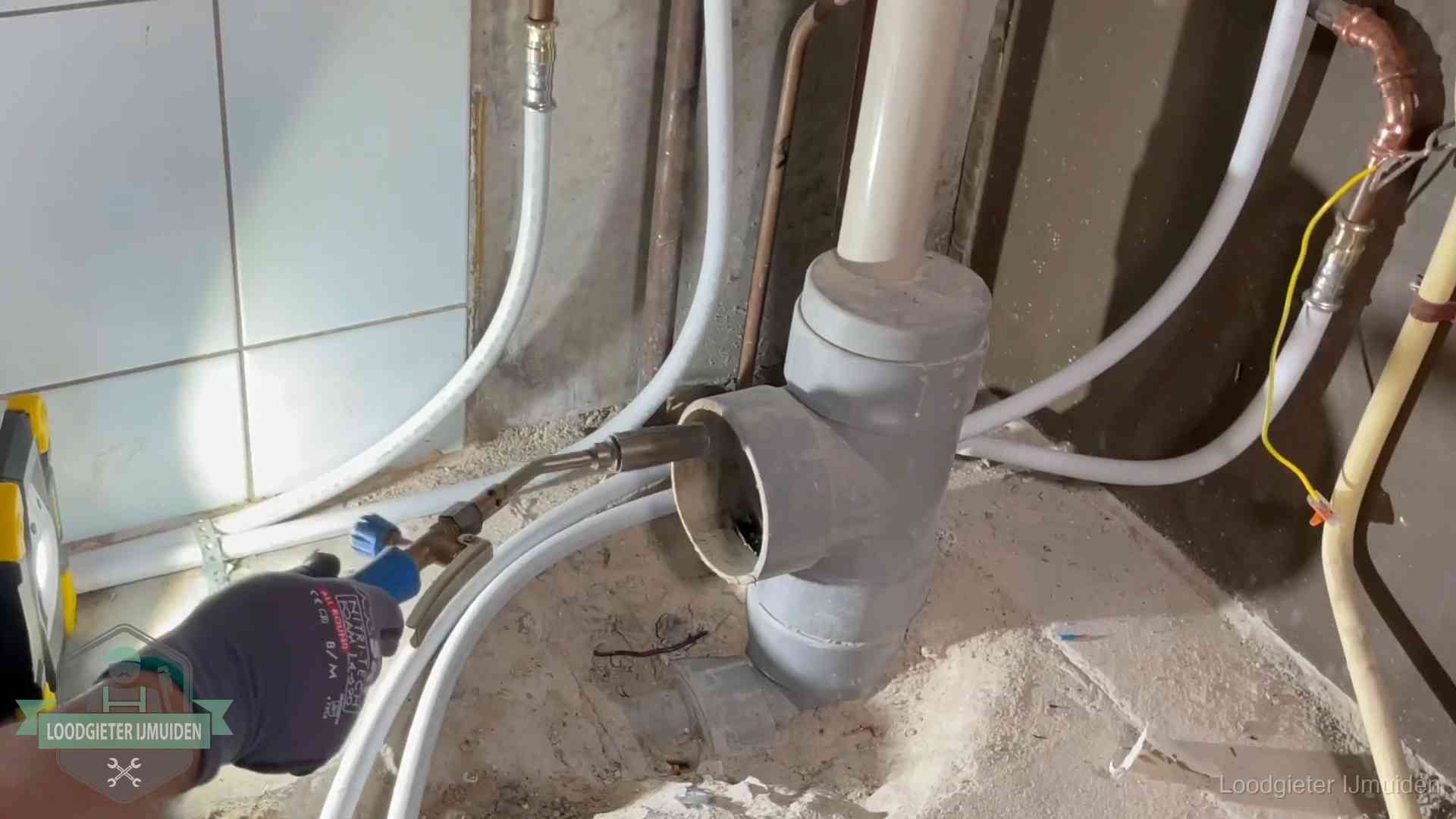 Verstopping in een huurwoning in IJmuiden Loodgieter werkt aan leidingen bij de pvc-standleiding van een huurwoning in IJmuiden