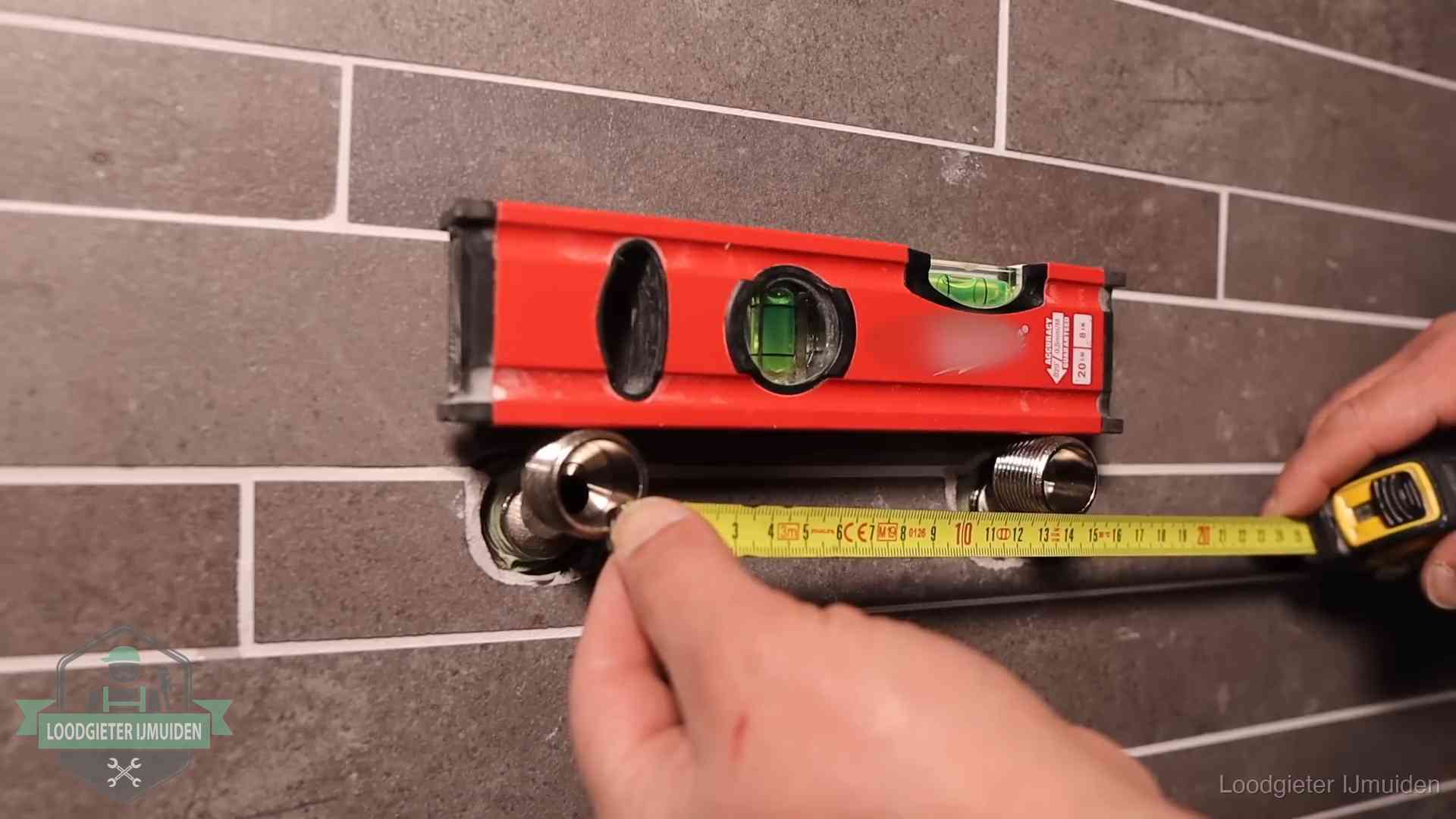 Kwaliteit en je vangnet als klant in IJmuiden Waterpas en duimstok bij kraan-aansluitpunten in een badkamer in IJmuiden