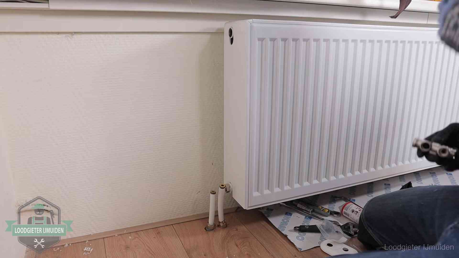 Verwarming per wijk in IJmuiden Nieuw gemonteerde radiator in een woonkamer in IJmuiden
