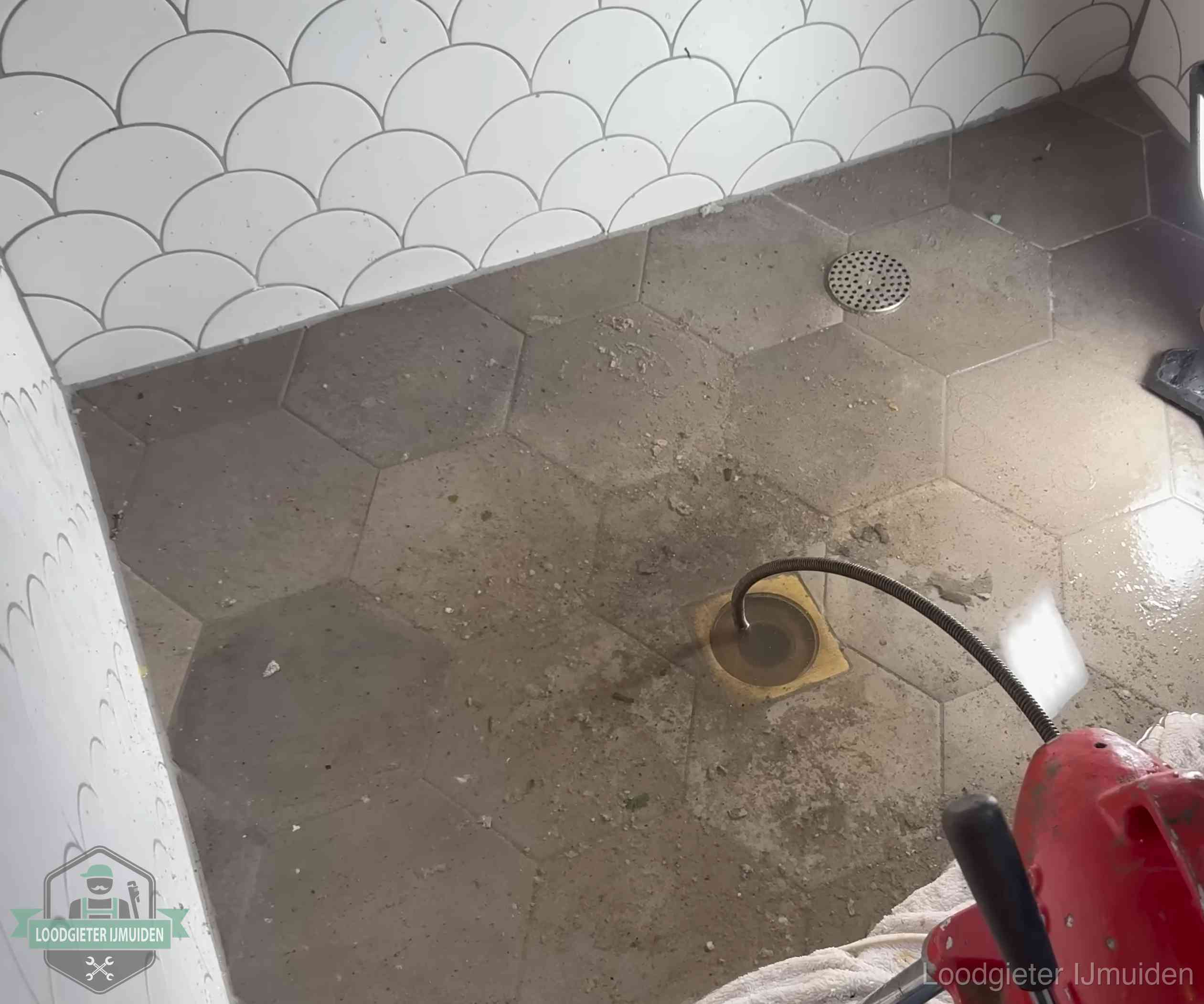 Vloerput met waterslot in een badkamer in IJmuiden, een bron van stank als het waterslot droogstaat