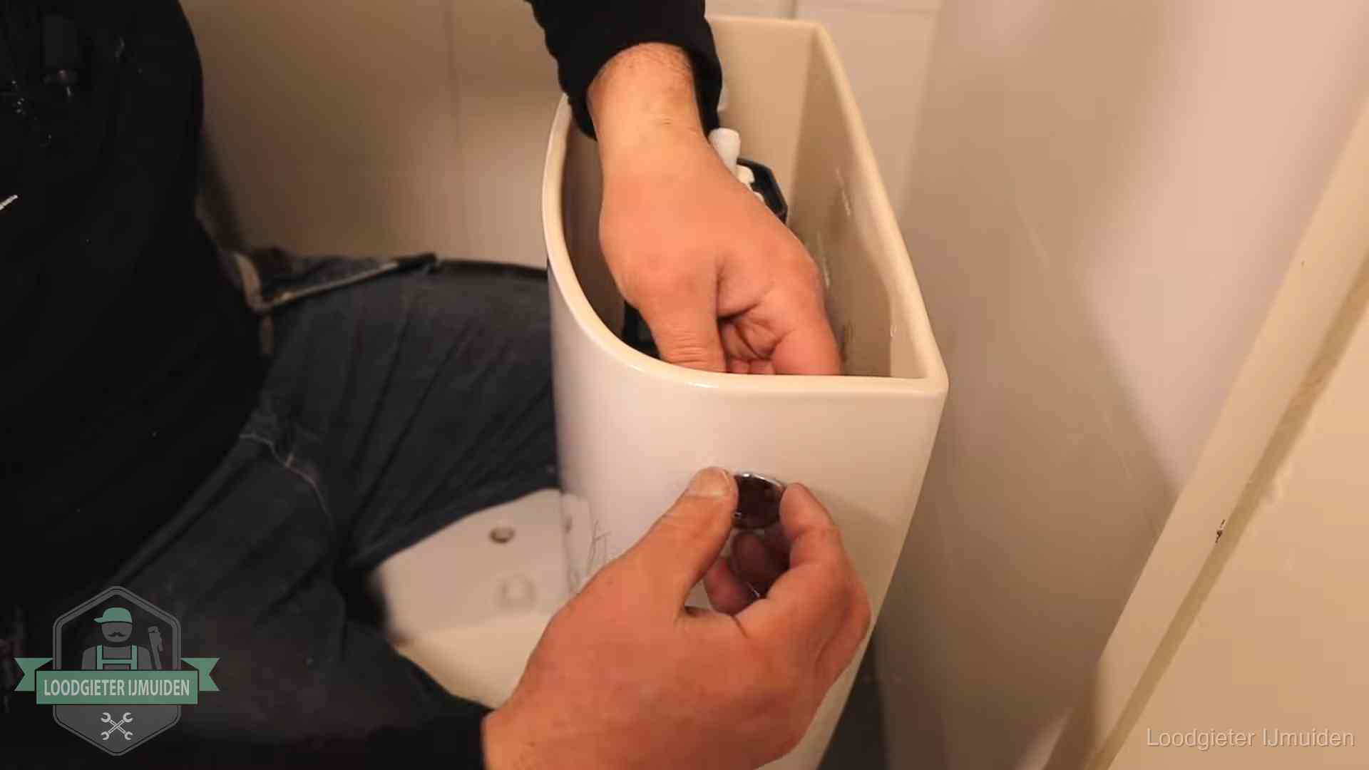 Drukknop van een duoblok-stortbak wordt gemonteerd bij een toilet in IJmuiden