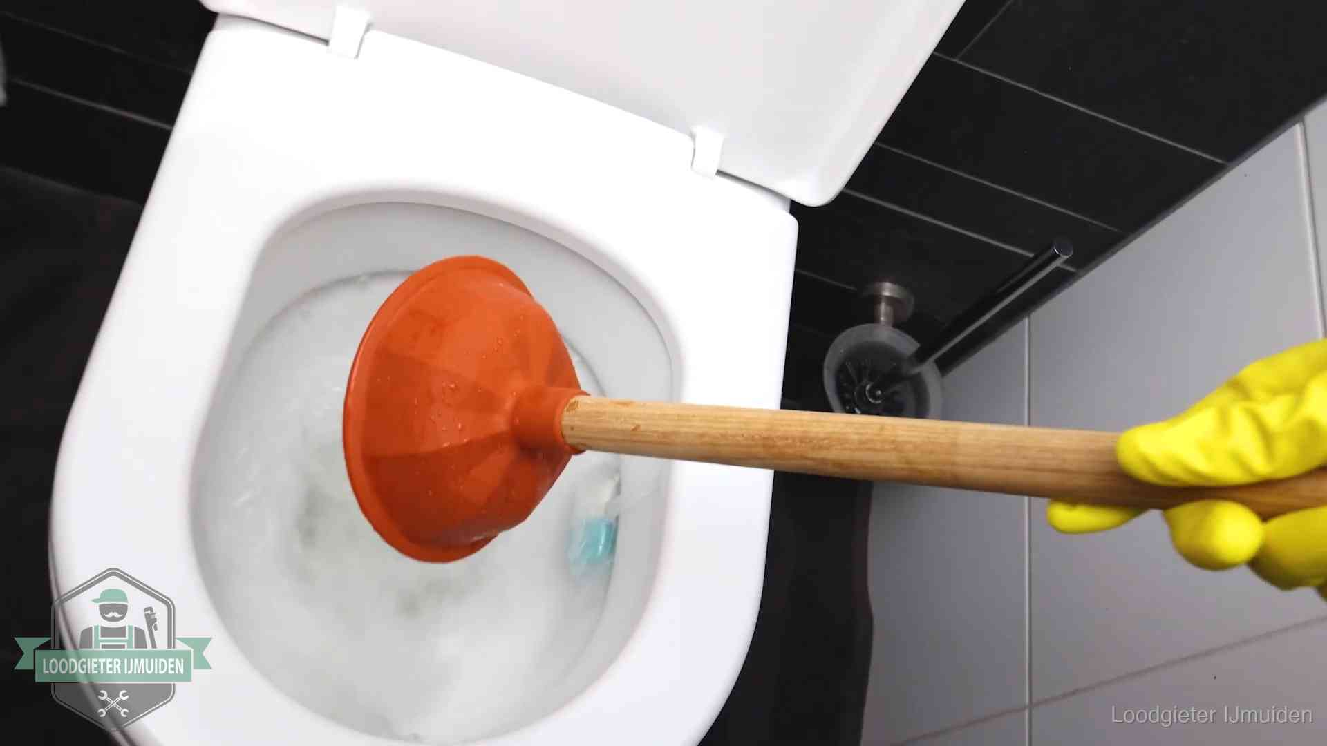 Plopper wordt in de wc-pot gedrukt bij het ontstoppen van een toilet in IJmuiden